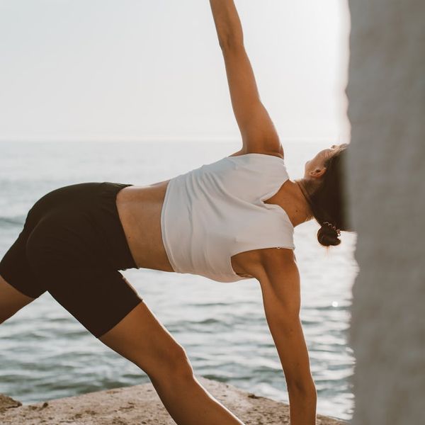 Person feeling energetic and stretching outdoors during sunrise.